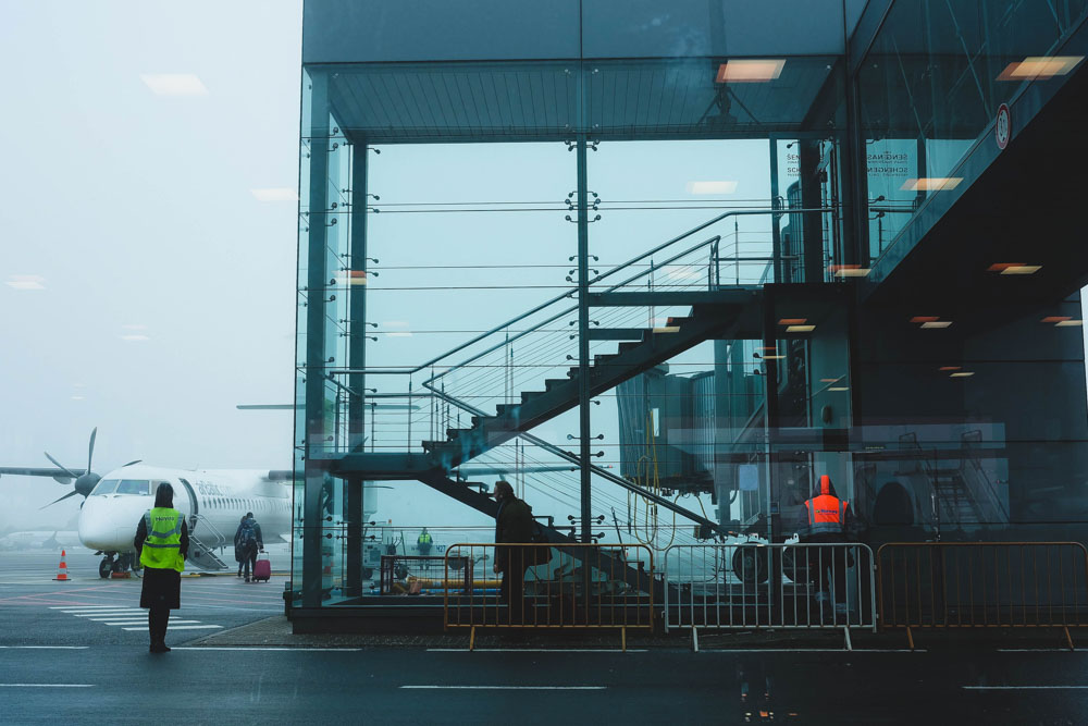Plane at the airport and person walking next to it