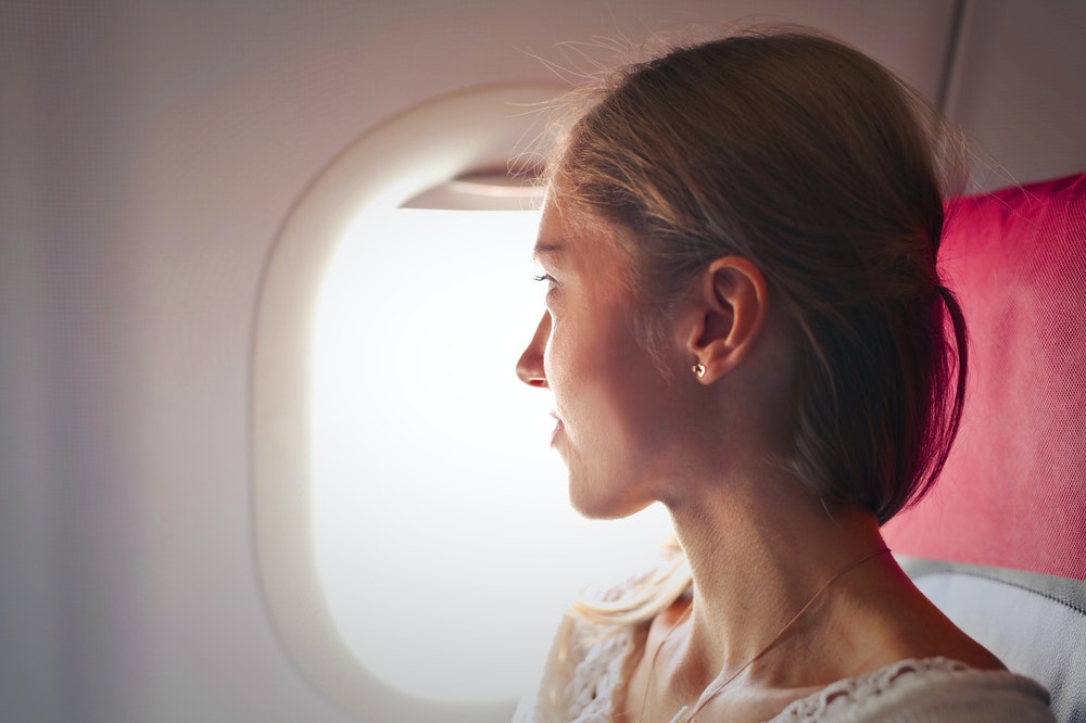 Woman sitting next to the window on an airplane