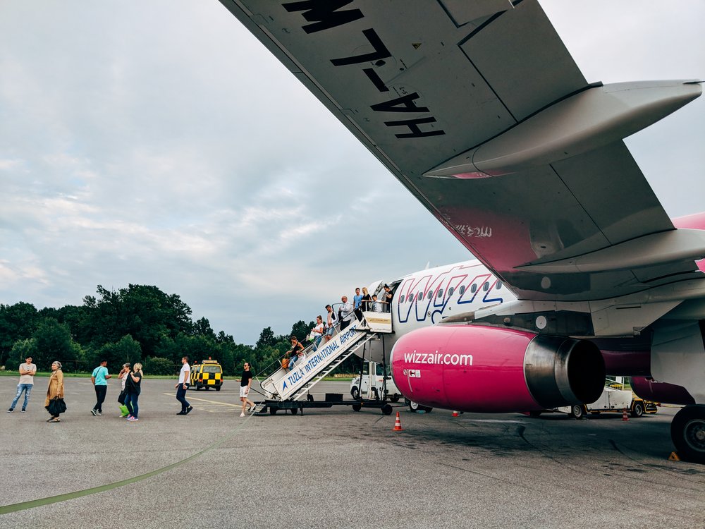 People leaving Wizz Air airplane parked at the airport